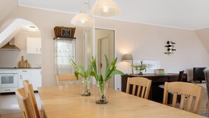 A dining area with a wooden table, chairs, and two glass jars with plants. - Apartment 'Schwanbergblick' with Shared Garden and Wi-Fi (Iphofen)