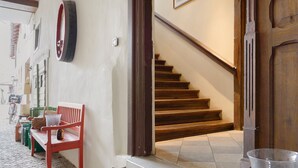 A staircase leading to a second floor, a red bench, and a wall-mounted tire. - Apartment 'Schwanbergblick' with Shared Garden and Wi-Fi (Iphofen)