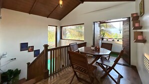 A spacious room with a wooden ceiling, a dining table with chairs, and a view of the outdoors. - Stay Leisurely Blue Leaf 3BHK Alibaug (Alibag)