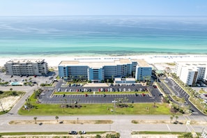A hotel with a parking lot, a beach view, and a road leading to the beach. - Islander Beach Resort 403 Condo (Fort Walton Beach)