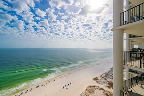A beachfront hotel with a balcony overlooking the ocean.