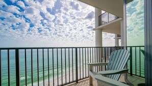 A balcony with a view of the ocean, a chair, and a railing. - The Oasis 2209 Formerly Phoenix West Ii 2209 3 Bedroom Condo (Orange Beach)