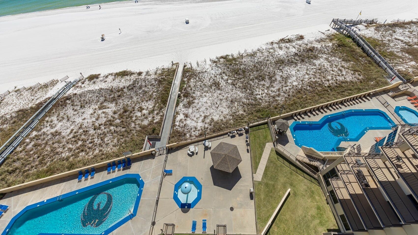 A resort with multiple swimming pools, a beach area, and a covered patio.