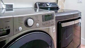 A front-loading washing machine with a control panel and a dryer stacked on top.