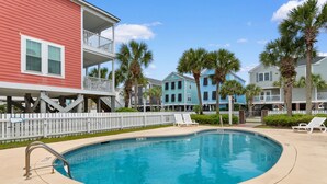 A swimming pool with a 5 FT depth marker, surrounded by a white fence, with multi-story buildings in the background. - Walk to Beach 4BR Home with Pool Near Pier (Surfside Beach)