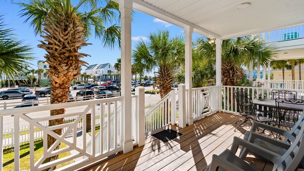 A covered outdoor area with wooden flooring, white railings, and outdoor furniture. - Walk to Beach 4BR Home with Pool Near Pier (Surfside Beach)