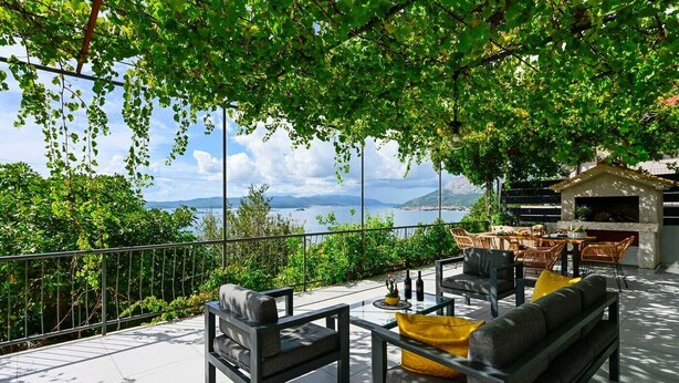An outdoor seating area with a view of a lake and mountains. - 2-Bedroom Holiday Villa Noa (Orebić)