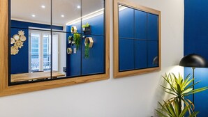 A room with a large mirror, a potted plant, and a lamp.