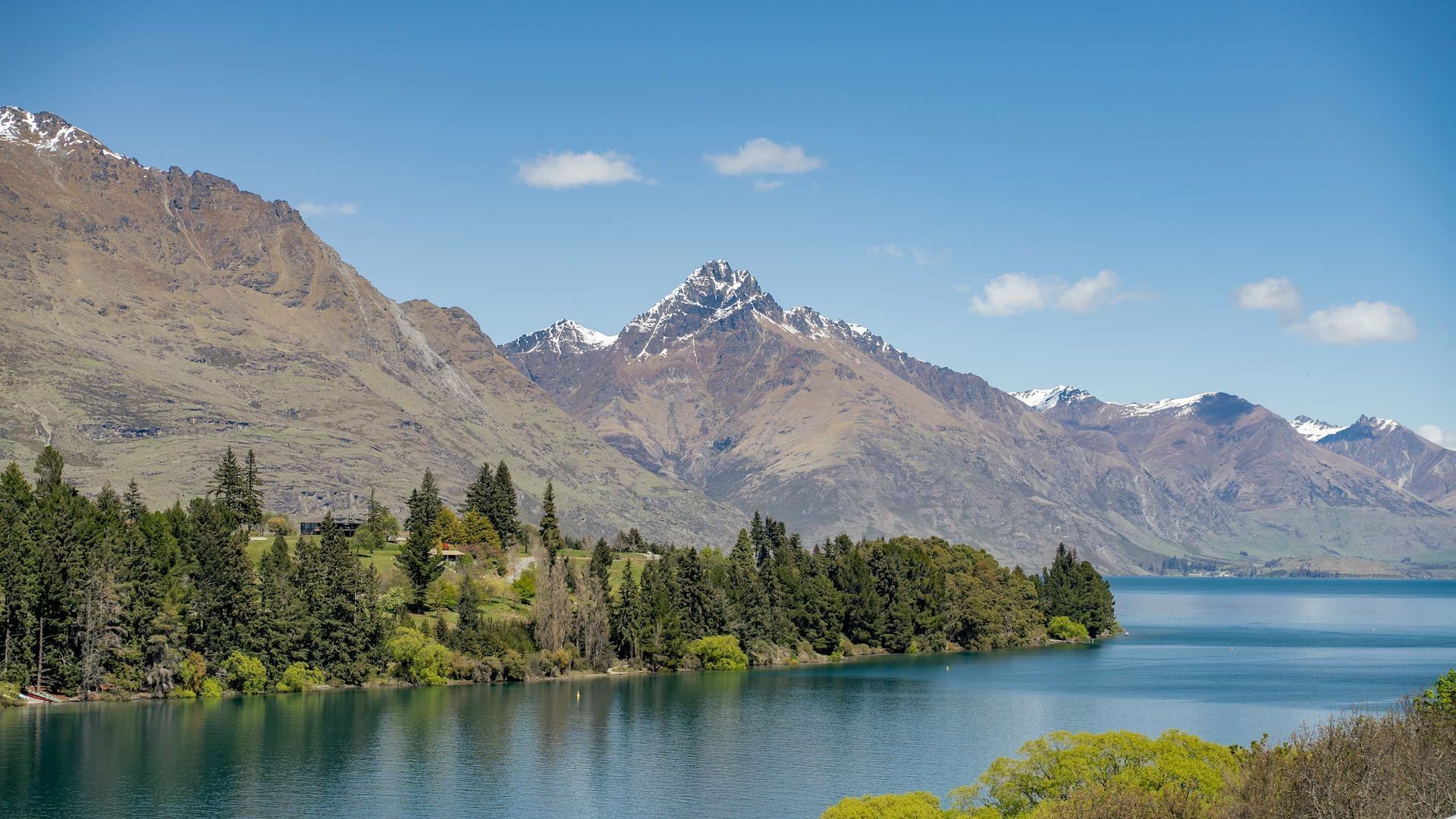 A mountainous landscape with a lake and forested area.
