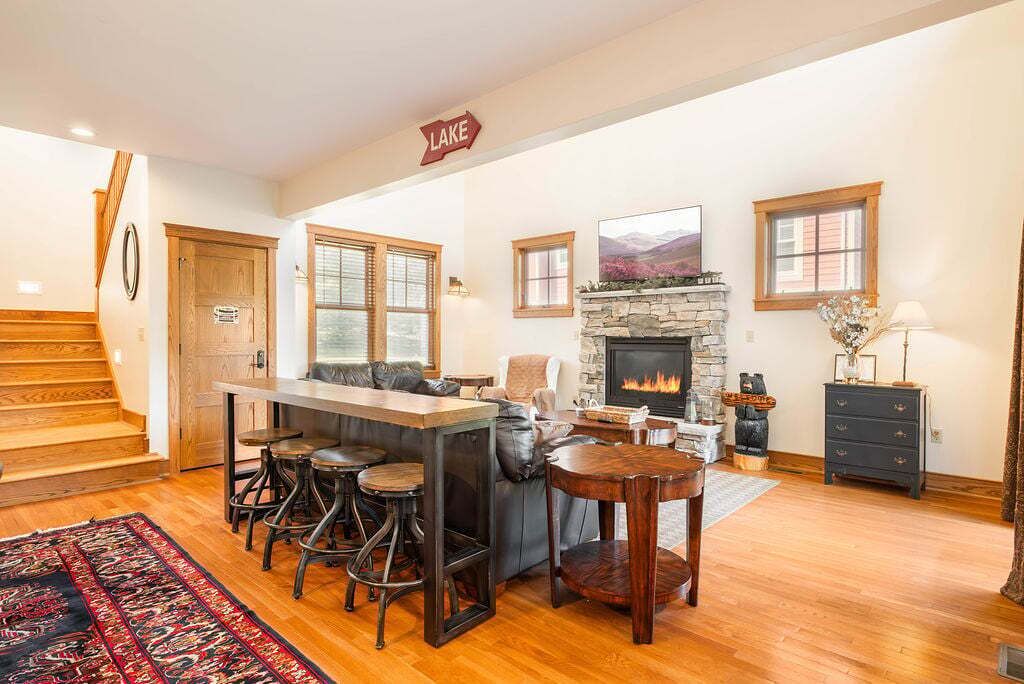 A cozy interior with a fireplace, a bar area, and a staircase.