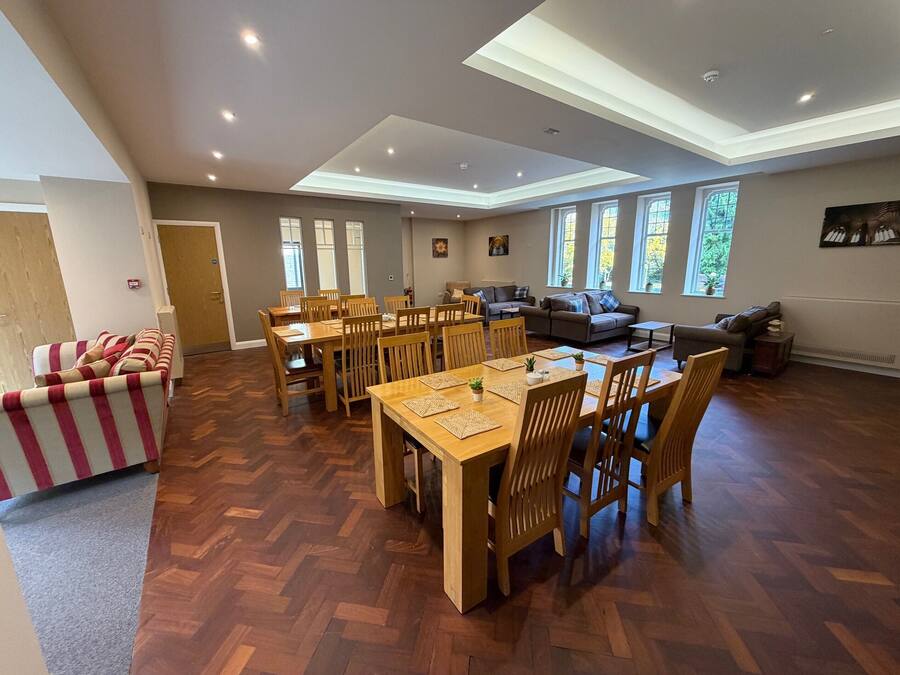 A spacious living area with a dining table, chairs, a sofa, and a fireplace.