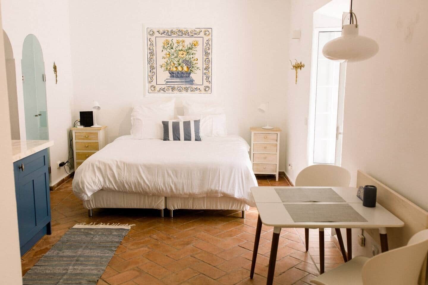 A bedroom with a bed, bedside tables, a desk, and a chair.