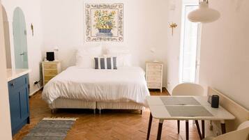 A bedroom with a bed, bedside tables, a desk, and a chair.