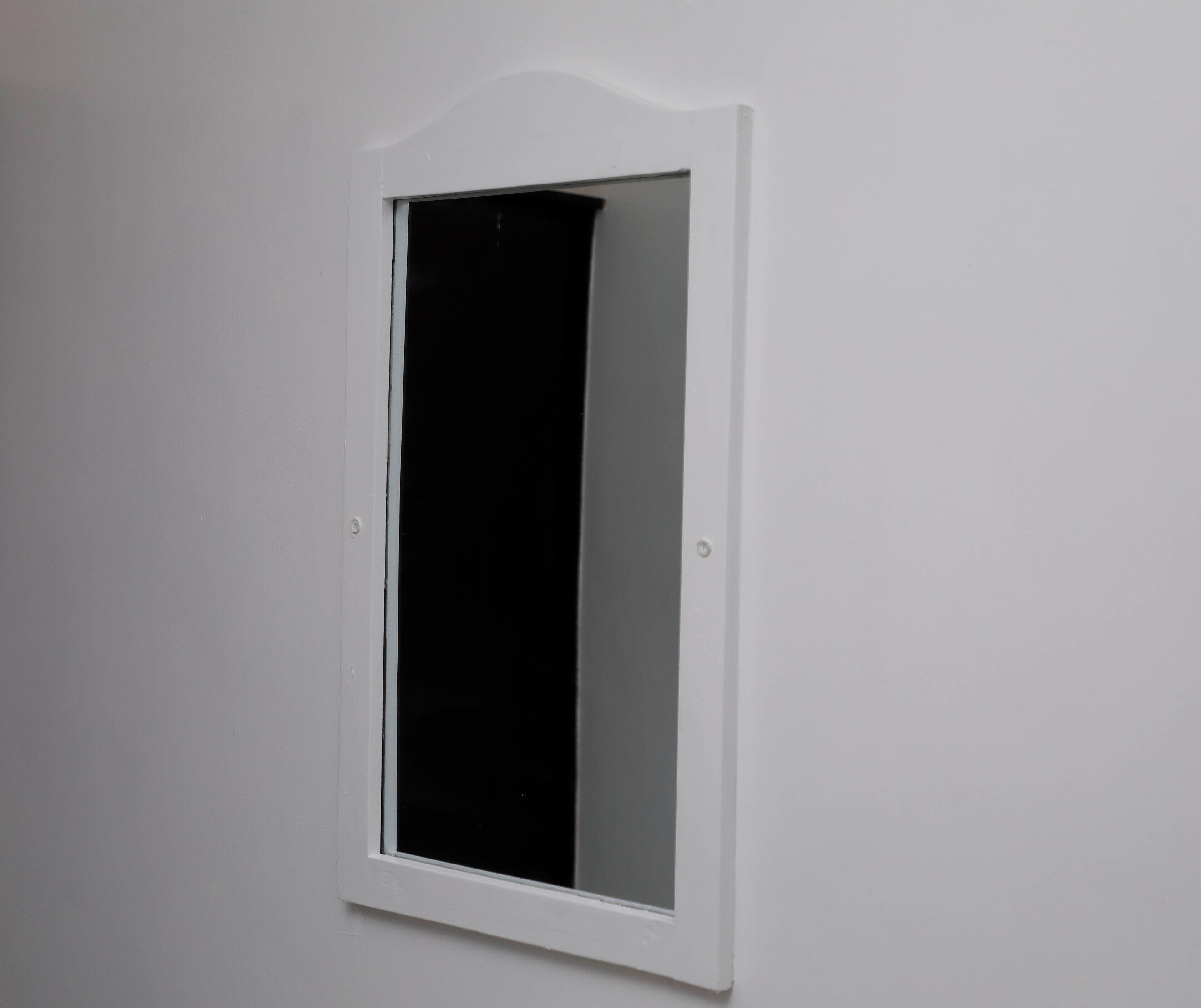 A white-framed window with a black curtain.