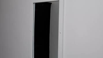 A white-framed window with a black curtain.