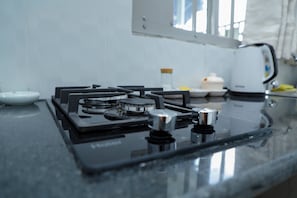 Cocina privada | Frigorífico pequeño, microondas, placa de cocina y utensilios de cocina