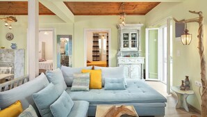 A spacious living room with a light blue sectional sofa, a wooden coffee table, and a rustic decor theme. - Orizzonte Blu - Three Bedroom Villa, Sleeps 6 (Corfu)