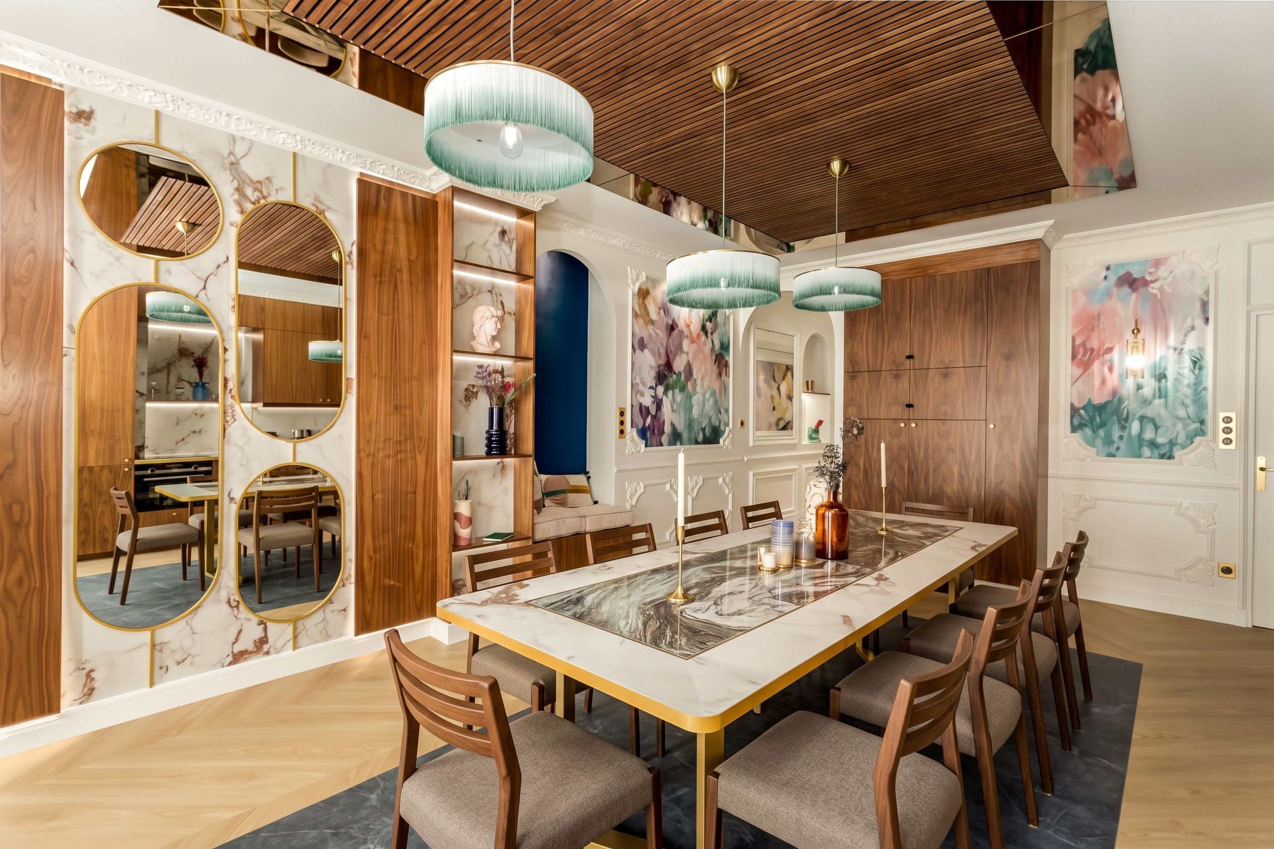A spacious dining area with a marble table, wooden chairs, and pendant lighting.