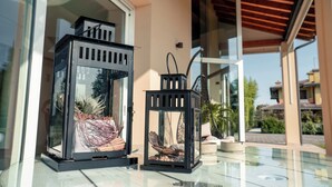 Two black lanterns with glass panels on a glass table outside a building. - Magrine Castelfranco Veneto  (Castelfranco Veneto)