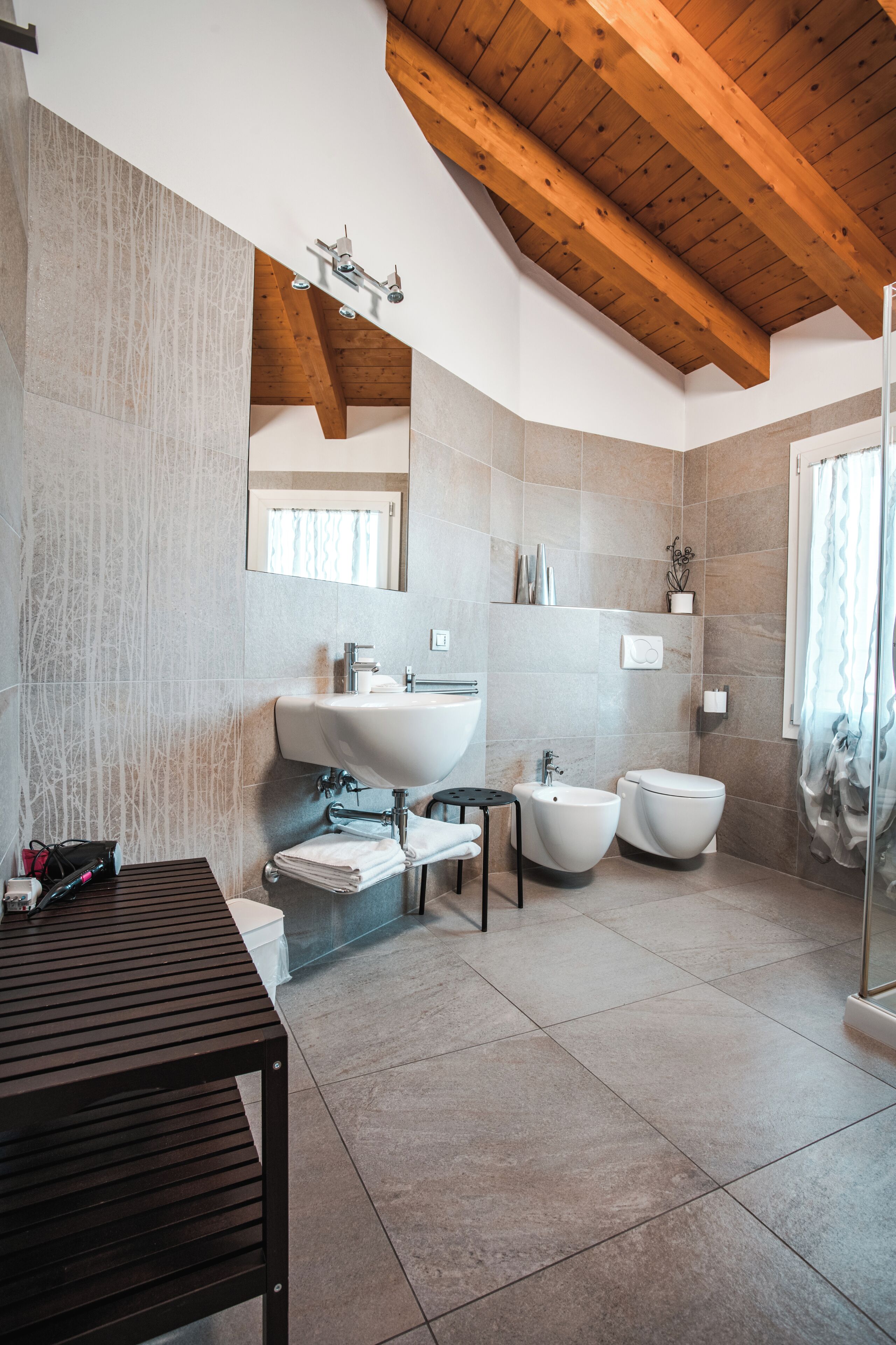 Un baño moderno con un lavamanos grande, bidé y ducha.