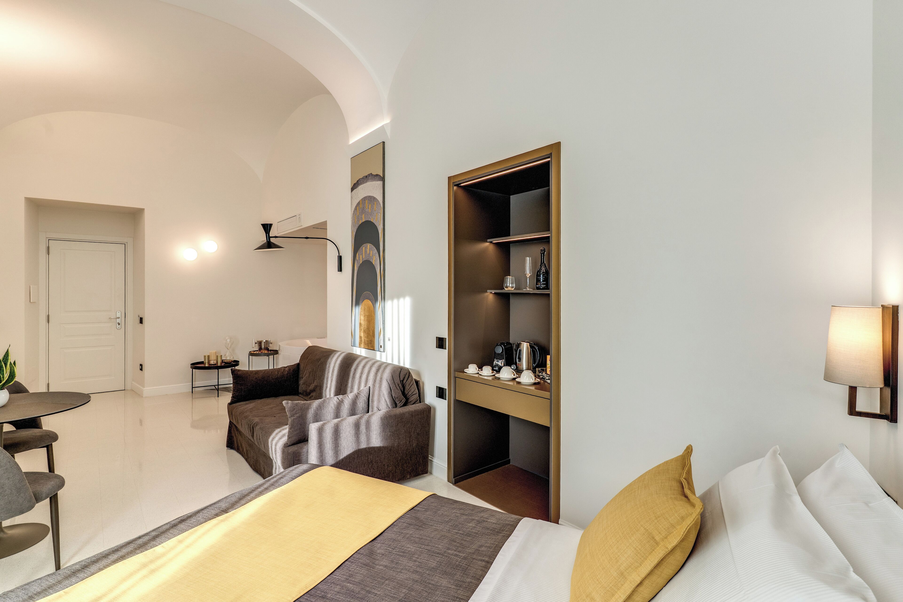 Una habitación de hotel moderna con cama, sofá, escritorio y armario.