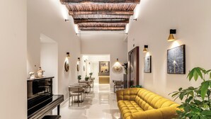 Una sala de estar moderna con un piano, sofá y comedor.