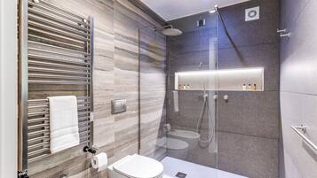 Un bagno moderno con doccia vetrata, un water e un porta asciugamani.