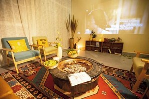 A living room with a round coffee table, a sofa, and a television screen. - Zhangjiajie perch tree house (Zhangjiajie)