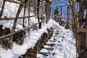 Een besneeuwde pad met houten leuningen en een stenen muur.