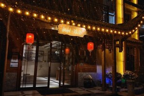 A traditional building with a sign, lanterns, and string lights. - Zhangjiajie perch tree house (Zhangjiajie)