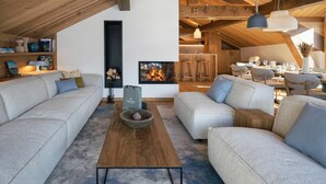 A modern loft with exposed wooden beams, a fireplace, a dining area, and a cozy seating arrangement. - Apartment for 10 people with sauna in Saint-Martin-de-Belleville (Saint-Martin-de-Belleville)