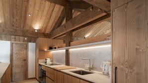 A modern kitchen with wooden cabinetry, a double sink, and a countertop with a kettle. - Apartment for 10 people with sauna in Saint-Martin-de-Belleville (Saint-Martin-de-Belleville)