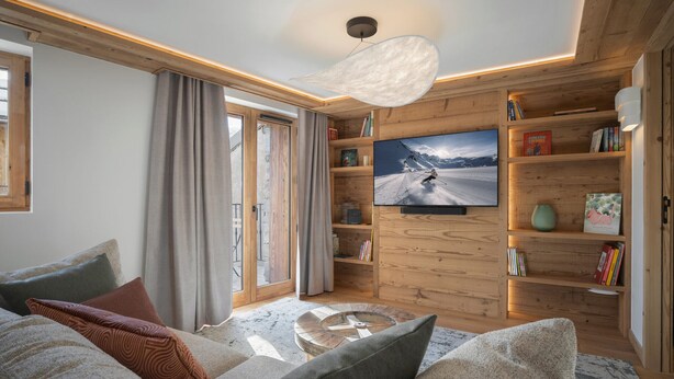 A cozy living room with a large flat-screen TV, wooden bookshelves, and a comfortable sofa. - Charming apartment for 4 near center (Saint-Martin-de-Belleville)