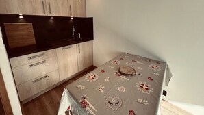 Ett kompakt kök med träskåp, en svart bänkskiva och ett litet handfat.