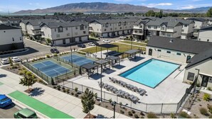 A residential complex with a swimming pool, tennis courts, and a parking area. -  New townhome, quick freeway & public trans. access, seasonal pool & pickleball. (American Fork)