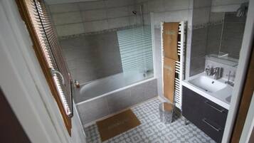 Un baño con ducha, bañera, lavabo y espejo.