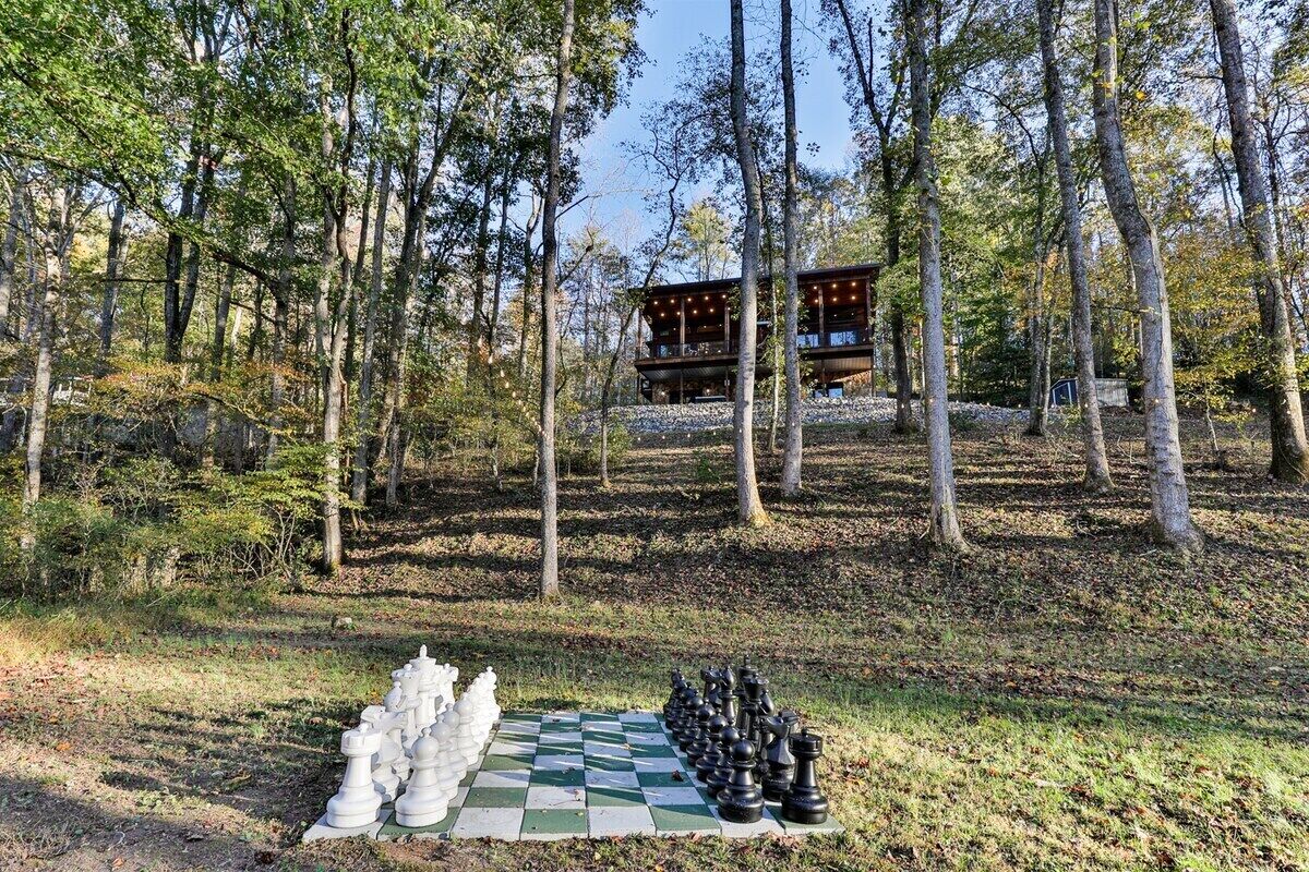 A forest with a chessboard and a cabin in the background.