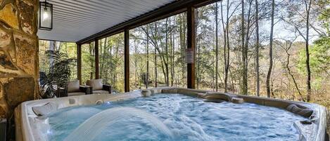 A hot tub with a view of a forest.