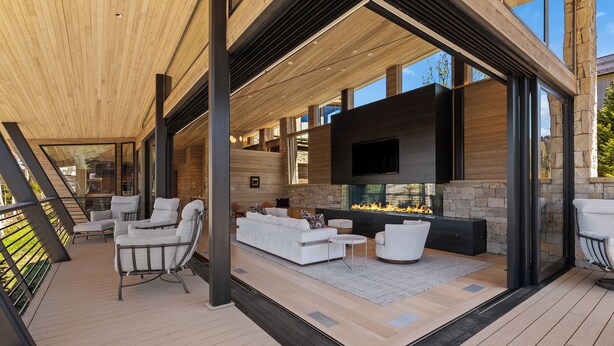 Un espacio moderno para disfrutar del aire libre con chimenea, asientos y vistas panorámicas.