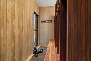 A wooden interior hallway with a directional sign indicating 'Taten' and a pair of skis on the floor. - Monteluce by Exceptional Stays (MOUNTAIN VILLAGE)