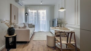 A modern living room with a sofa, a round dining table, and a TV. - RentPlanet - Apartament Braniborska IV (Wrocław)