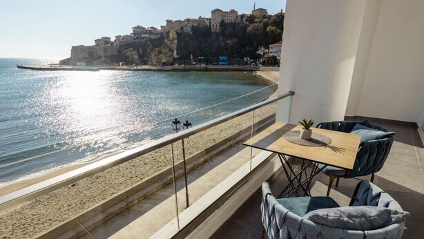 A balcony with a view of the sea and a distant town. - Hotel Continental Ulcinj (Ulcinj)