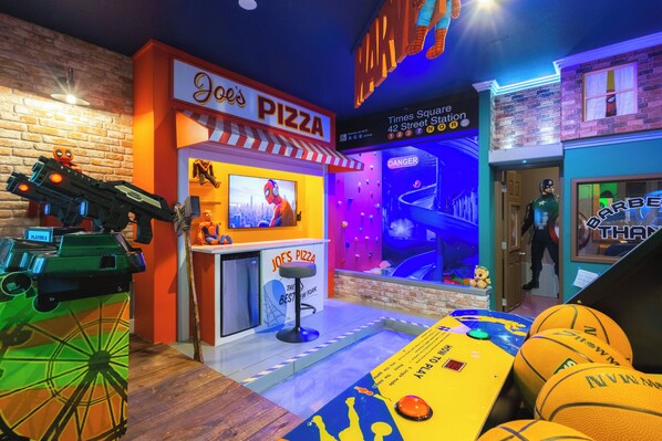 A themed restaurant with a pizza stand, a bar, and a Spider-Man display.
