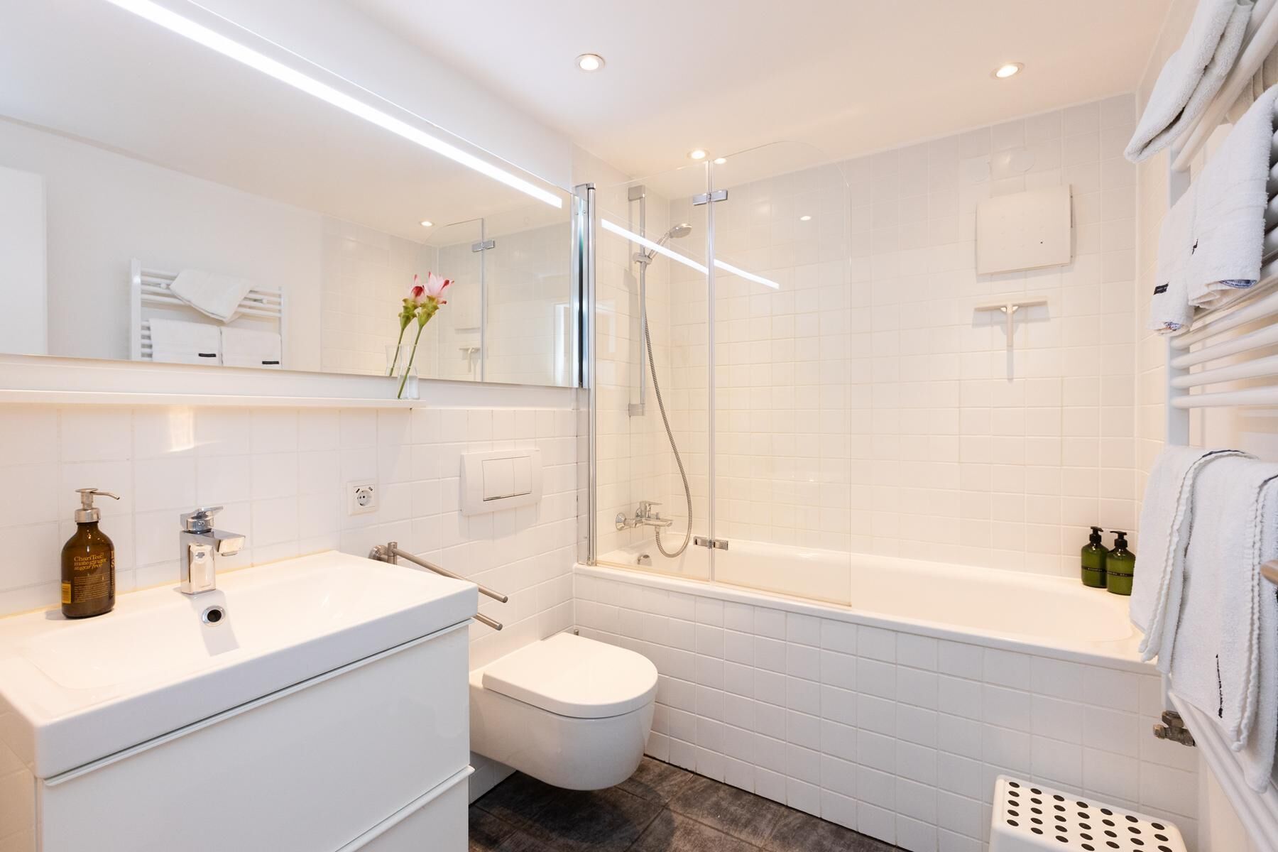 Ein modernes Badezimmer mit Toilette, Waschbecken und Dusche.