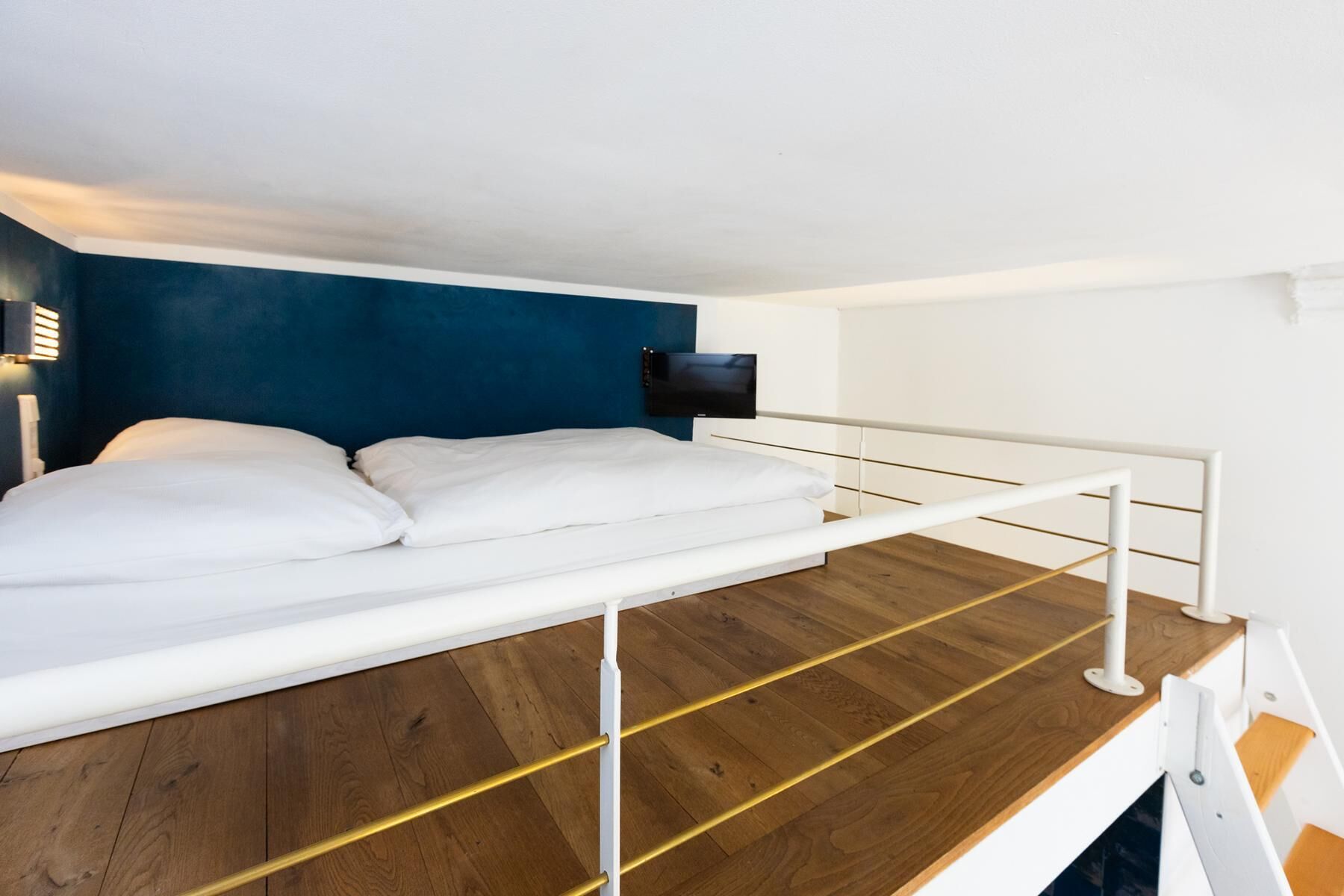 Ein Stockbett mit einem an der Wand darüber befestigten Fernseher.