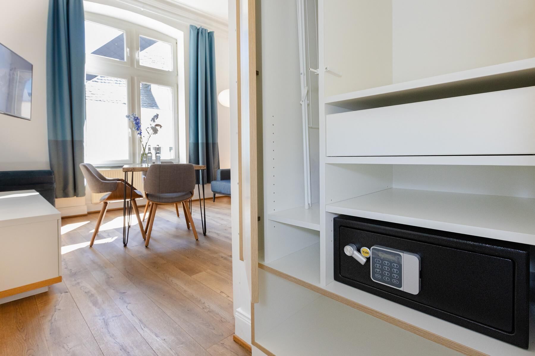 A room with a desk, chair, and a Yale safe.