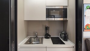 A compact kitchen with a stainless steel sink, a microwave, and a coffee maker. - Beachfront Studio With Terrace by Wonderful Italy (Genoa)