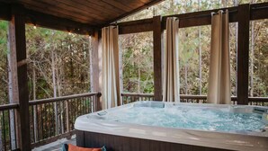A hot tub on a wooden deck with a view of trees. - Movie under Stars, Heated Pool, Pickle ball, Slide (Broken Bow)