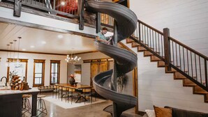 A spacious living area with a central spiral staircase, a dining area, and a kitchen.