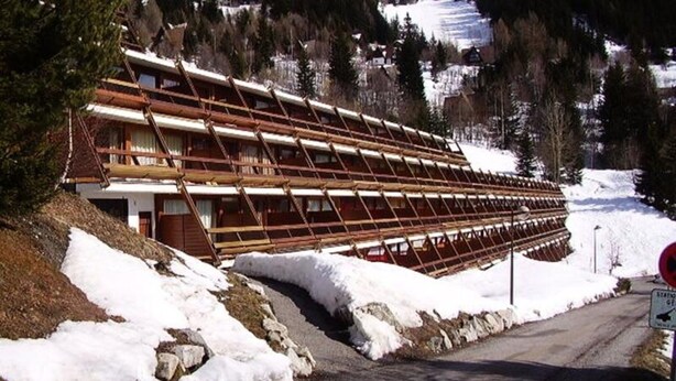 A multi-story wooden building with a sloped roof, surrounded by snow and trees. - Pleasant 2-room Apartment for 7 People in Arc 1600 in a Residence With Outdoor Swimming Pool Close to the Slopes and Shops (Bourg-Saint-Maurice)